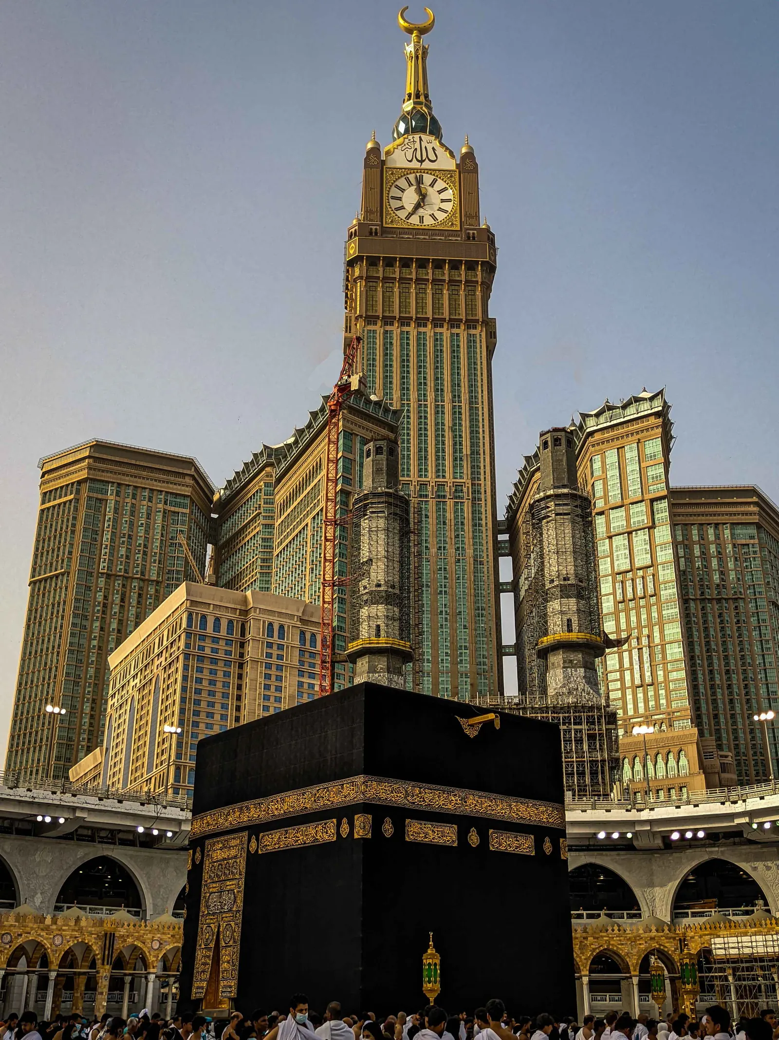 The Kaaba at night with the clock tower rising behind it