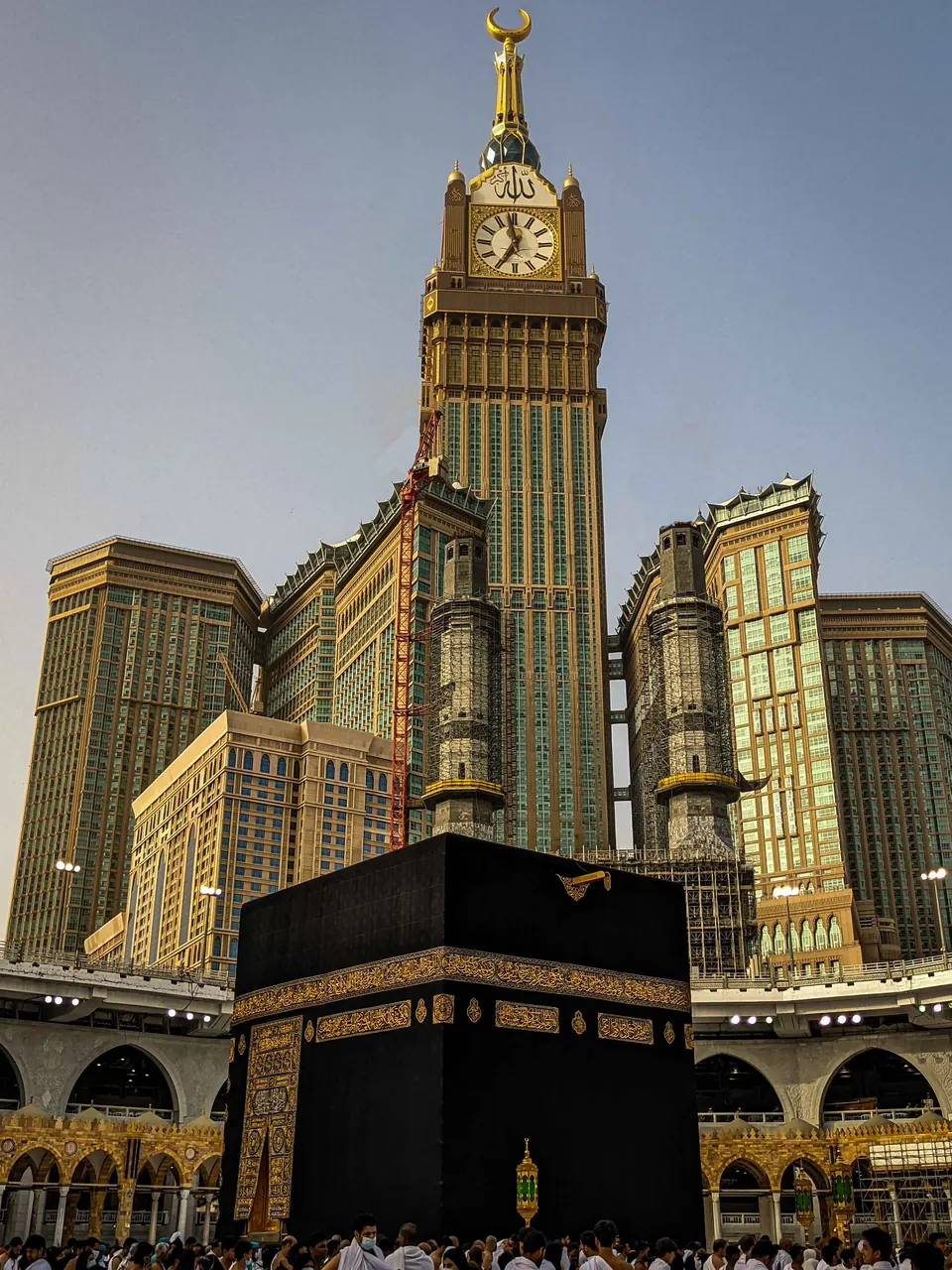 The Kaaba at night with the clock tower rising behind it
